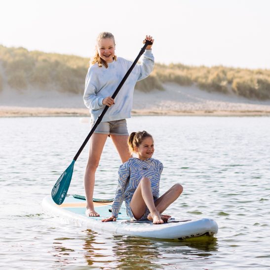 Two kids having fun on a single MOAI SUP board on the water